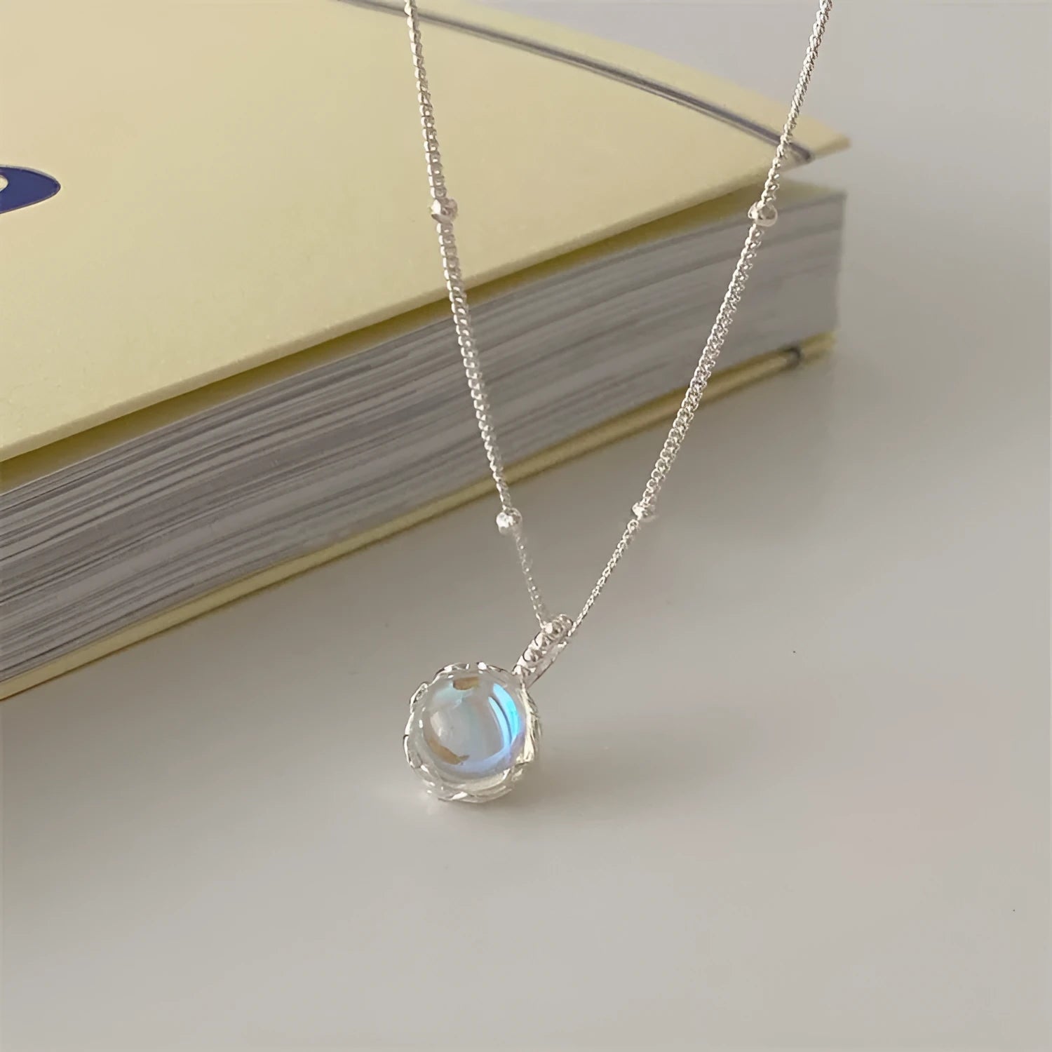 Women's ornamental stone necklace with round 925 silver pendant on a silver curb chain, adjustable length.