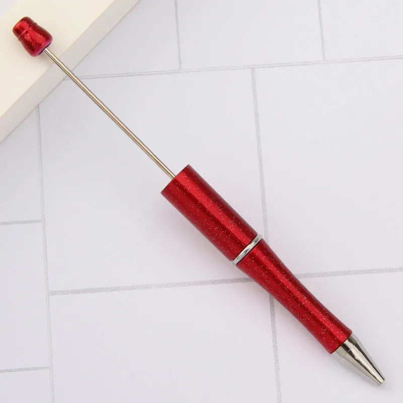 Colourful spinning ballpoint pen with plastic beads on a white background.