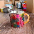 American style painted synthetic resin decorative coffee cup ornament on a shelf.