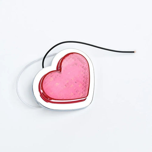 Heart-shaped red LED car fender sidelight on a black background.