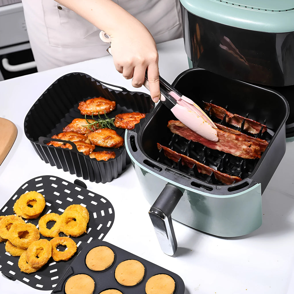 Black silicone square baking tray set for air fryer, 4 pieces on a light background