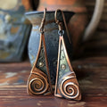 Bronze alloy geometric spiral earrings with irregular shape on a neutral background