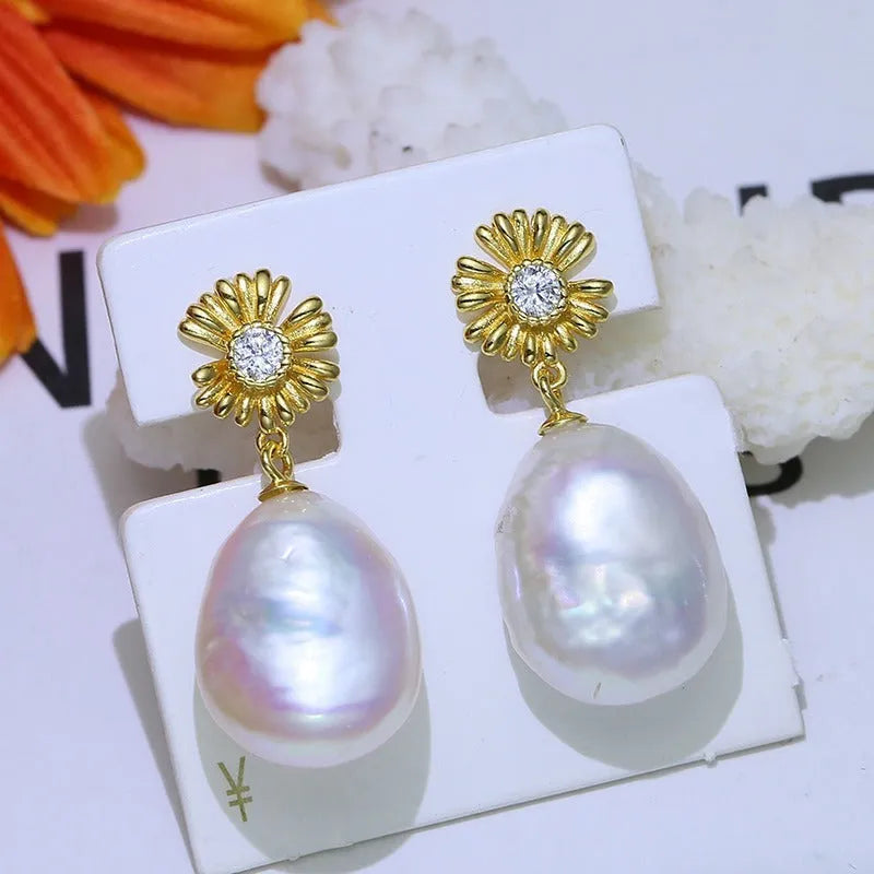 A pair of Baroque-style floral earring frames made of sterling silver, featuring a small integrated ring holder, presented without pearls.