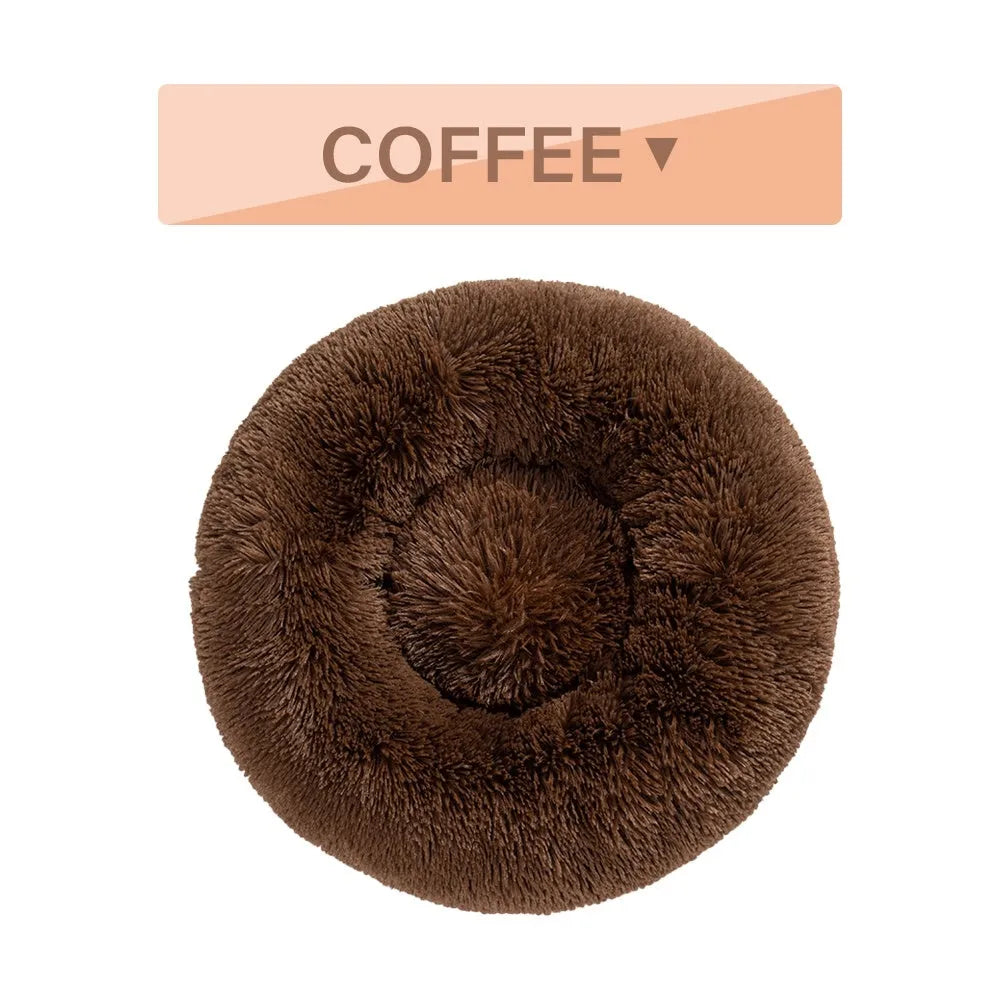 A fluffy, round donut-shaped dog bed with a raised rim in long plush fabric.