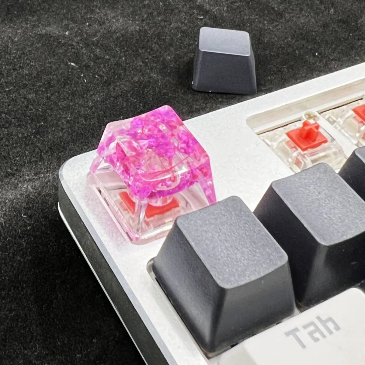 High transparency resin keycap with starry sky design in green, pink, red and violet colours.