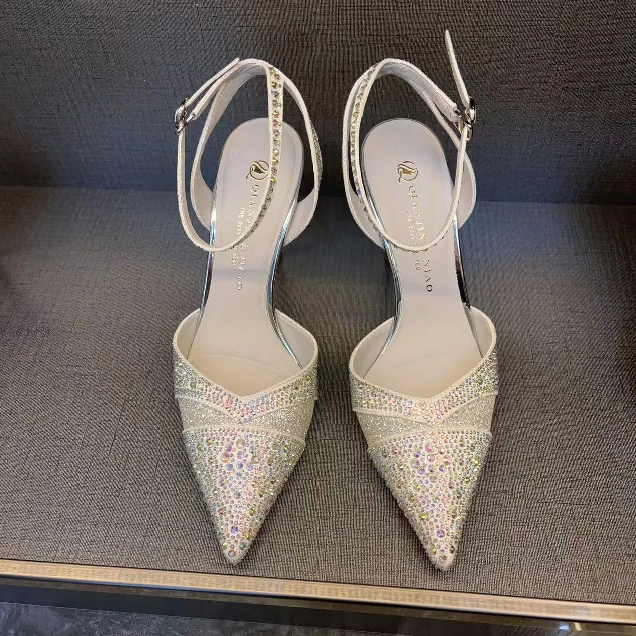 Women's black and silver hollow-cut stiletto heels with a pointed toe and shallow mouth design.