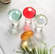 Small solid crystal mushroom ornament in modern geometric style on a wooden surface.