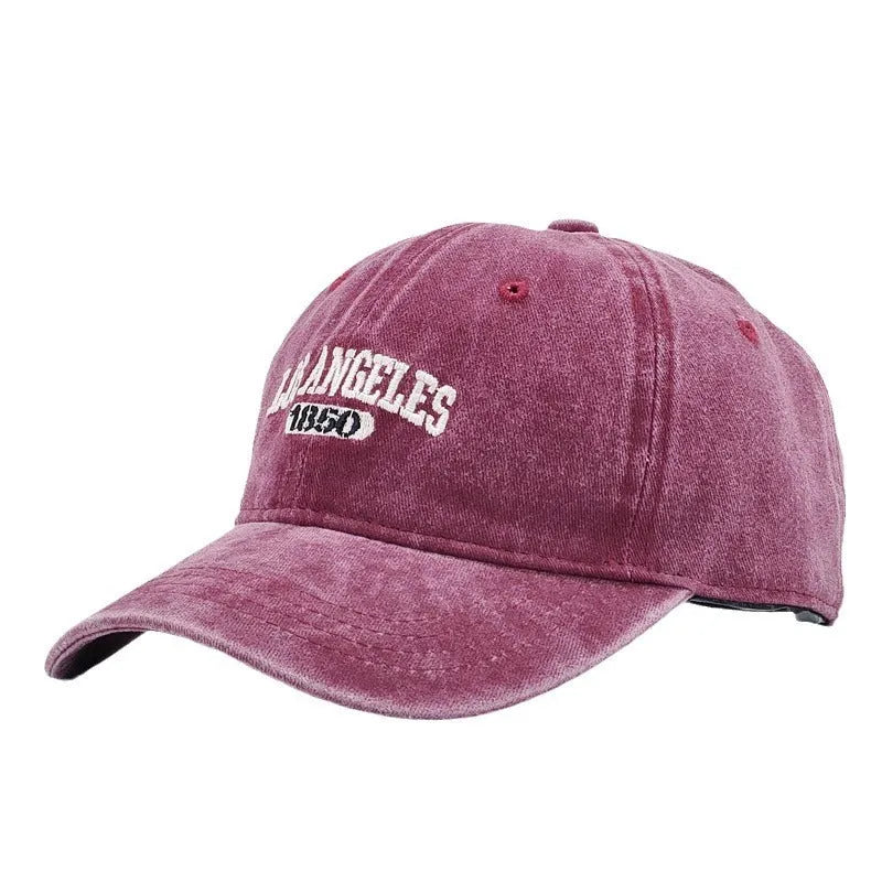 Retro-style personalised embroidered peaked cap with adjustable strap on distressed beige fabric.