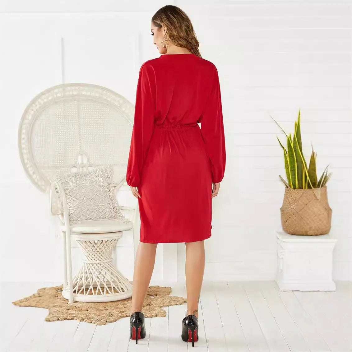 Women's black A-line midi dress with elastic cuffs and a waist cinching belt.