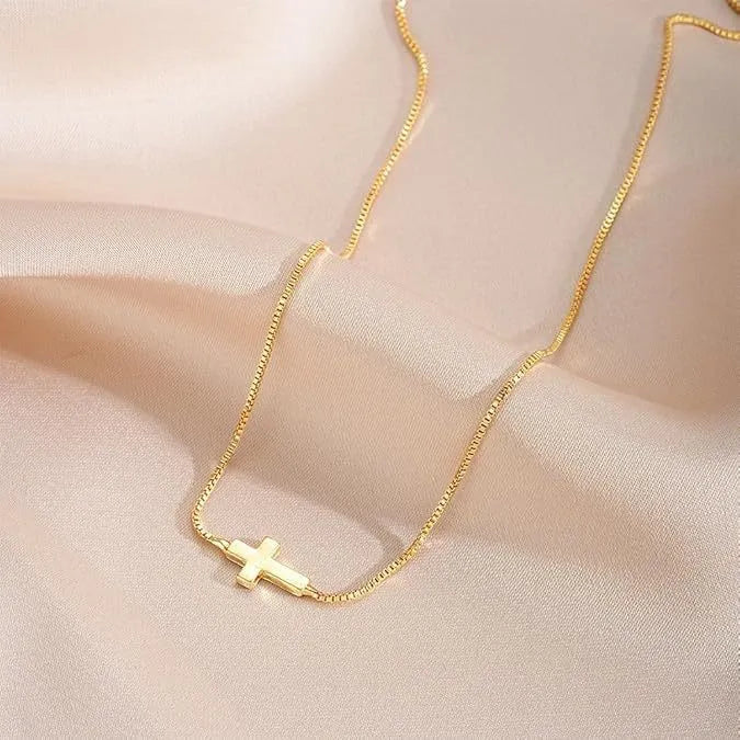 Miniature cross pendant necklace for women in alloy, dainty style on display