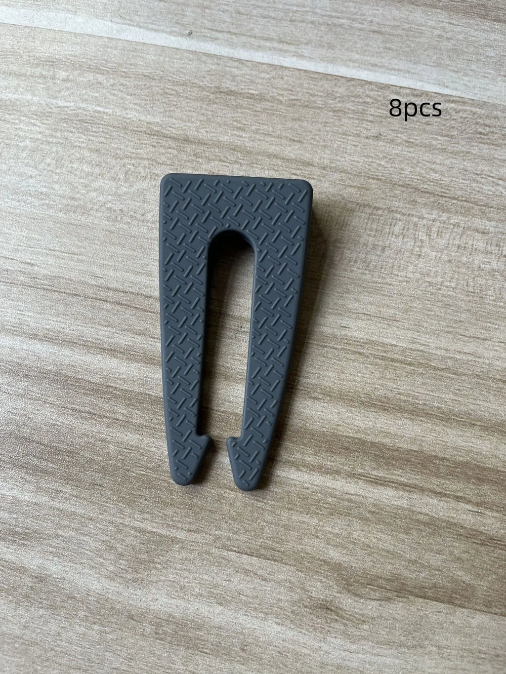 Gray plastic gas stove knob safety lock clipped onto a gas cooker knob showing side profile