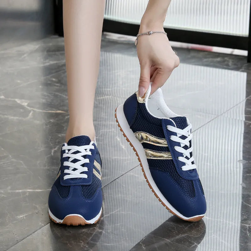 Blue women's lightweight sports shoes with cross straps and lace-up front on a flat rubber sole.