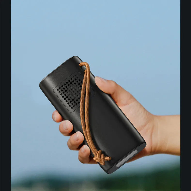 Black portable power bank with 220V AC outlet, USB ports, and solar charging panel.