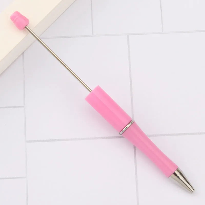 Colourful spinning ballpoint pen with plastic beads on a white background.