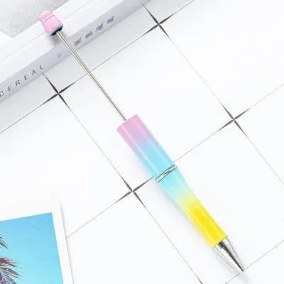 Colourful spinning ballpoint pen with plastic beads on a white background.
