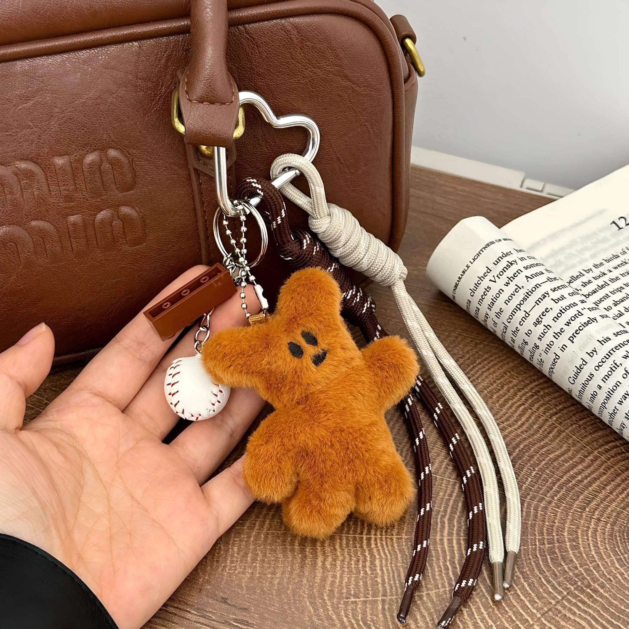 Brown plush bear pendant keychain attached to a bag, soft toy decoration