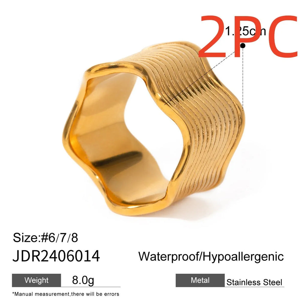 Stainless steel wide band ring with a geometric wave pattern, shown in an electroplated colour option.