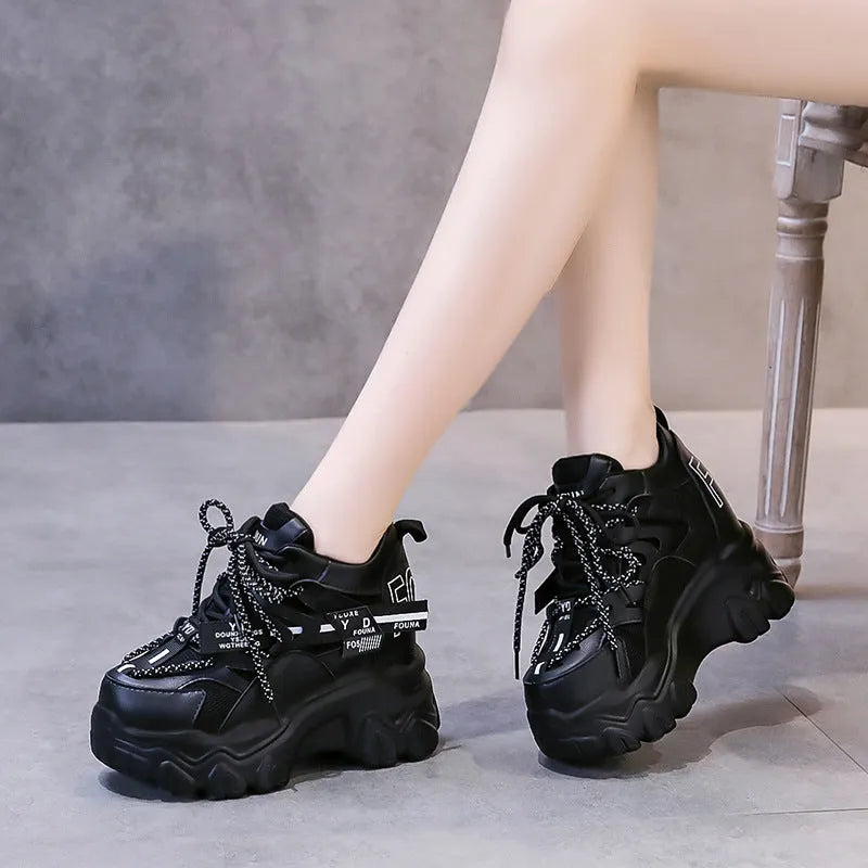 White women's low-top platform sports shoes with cross-strap detail on a rubber sole.