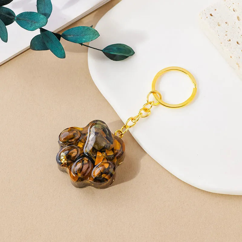 Hand-carved natural crystal cat's paw keychain pendant on a metal ring, showing unique gemstone colour.