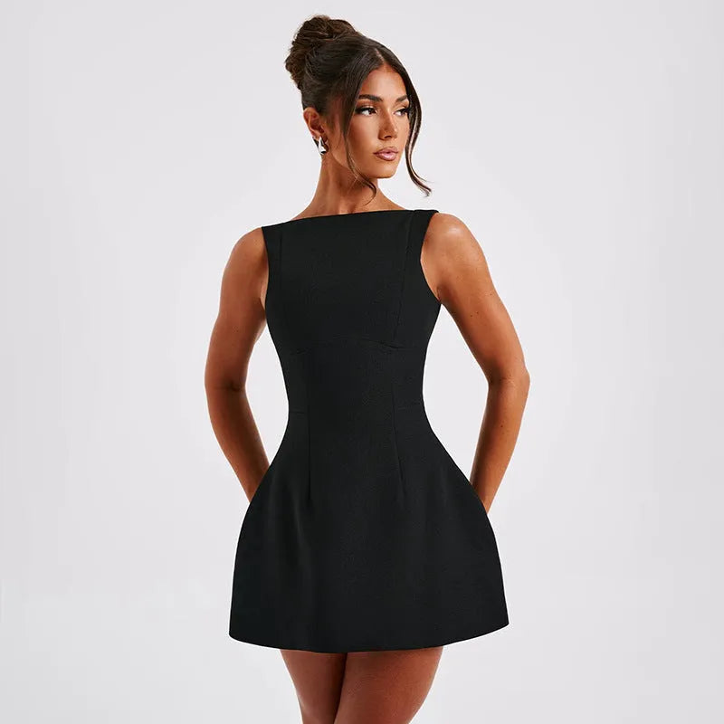 A woman wearing a black backless sling dress with a high waist and short skirt.
