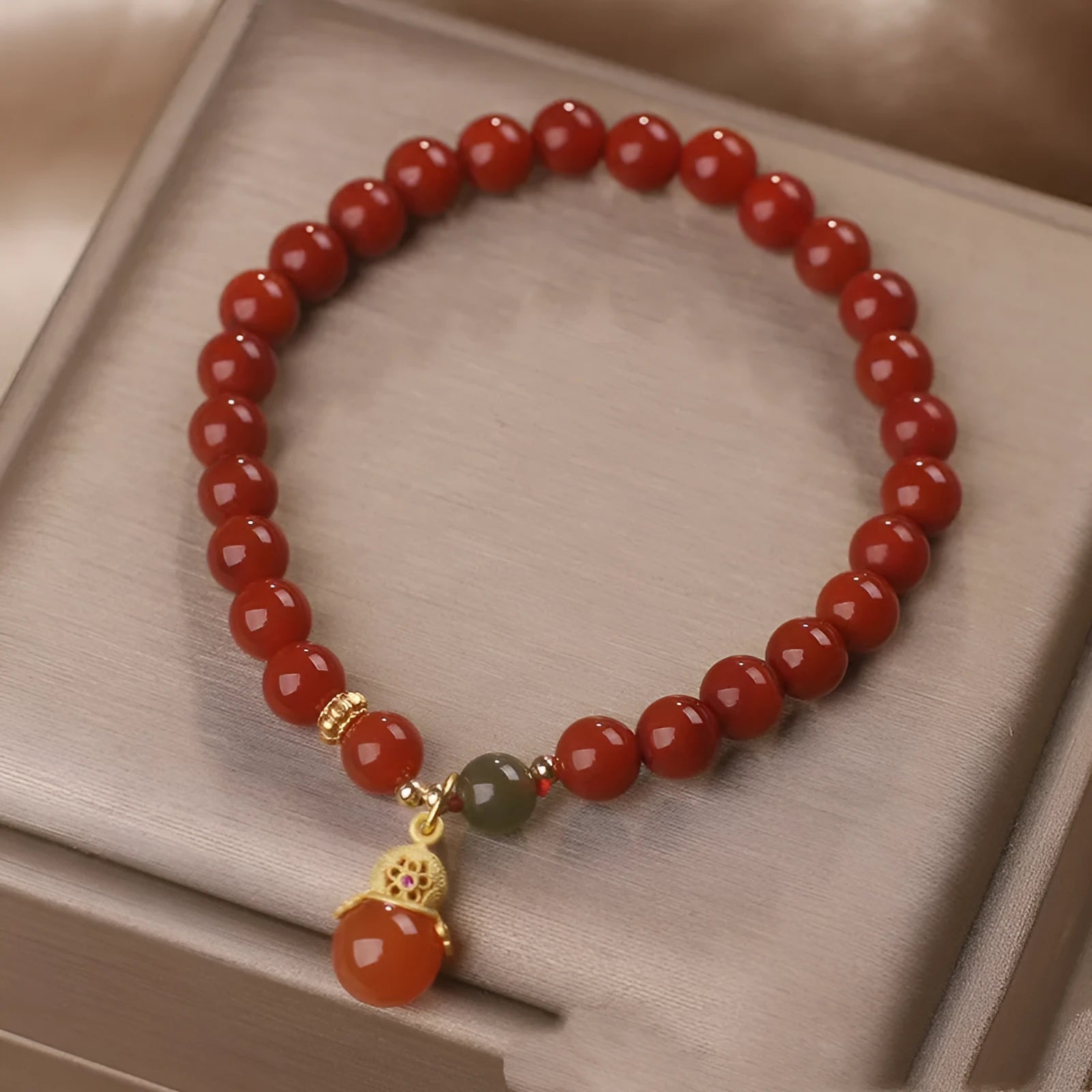Red agate and Hetian jade bracelet with lucky beads pendant on display