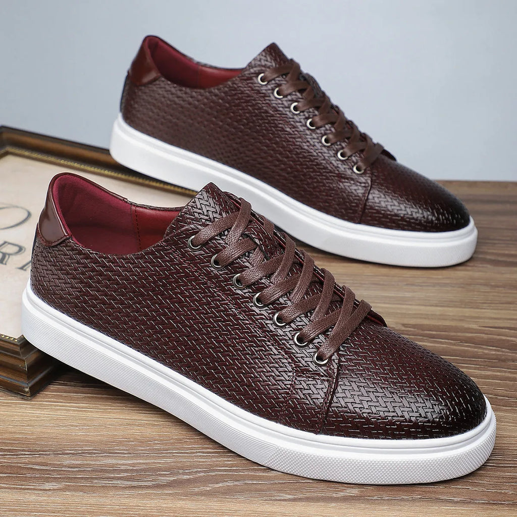 Men's low-top black leather-style shoes with decorative stitching and a rubber sole.