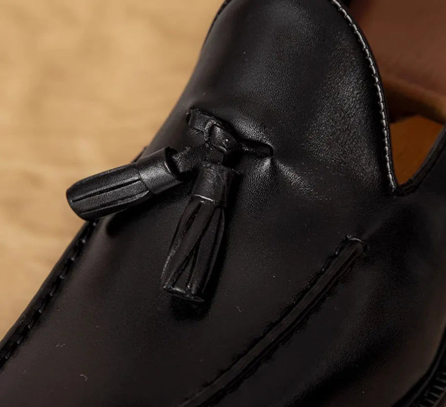 Men's black and brown genuine leather slip-on loafers with a fringed detail and rubber sole.