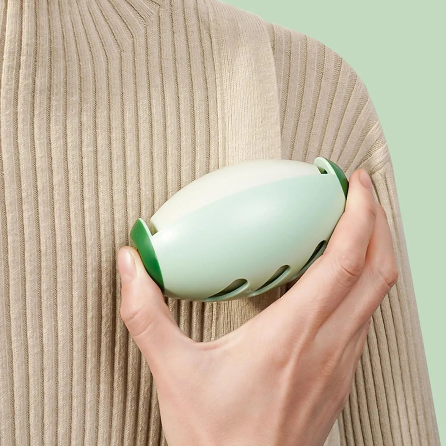Green and white reusable gel lint roller ball for removing pet hair and lint from clothes.
