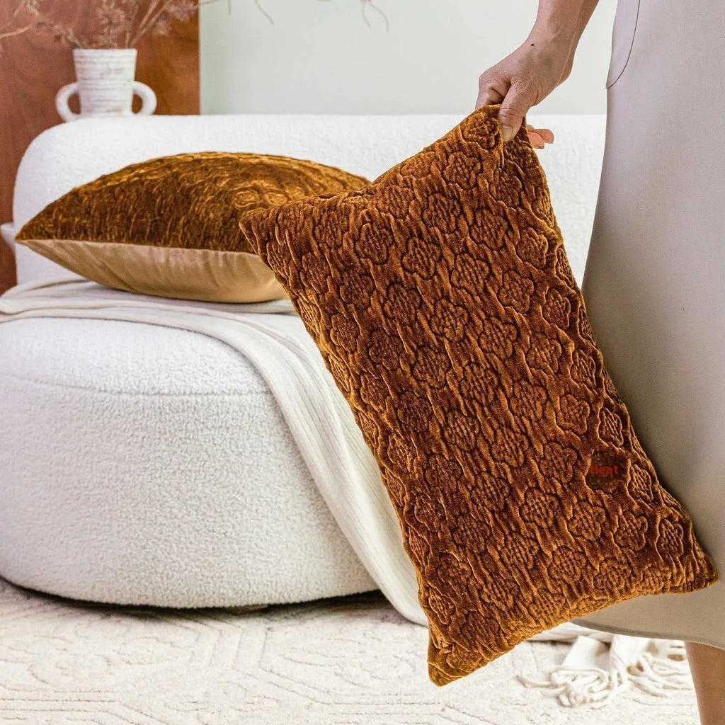 Brown gold antique style quilted square cushion with three-dimensional texture on a sofa.