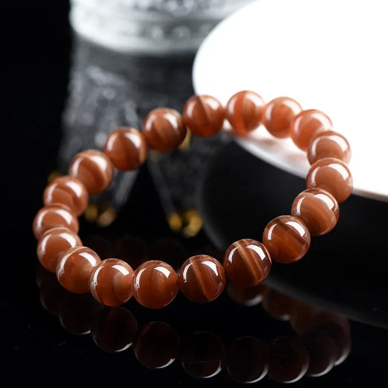 Natural Old Mine Rhodochrosite round bead bracelet with Ruyi design, shown in 6mm and 8mm sizes.