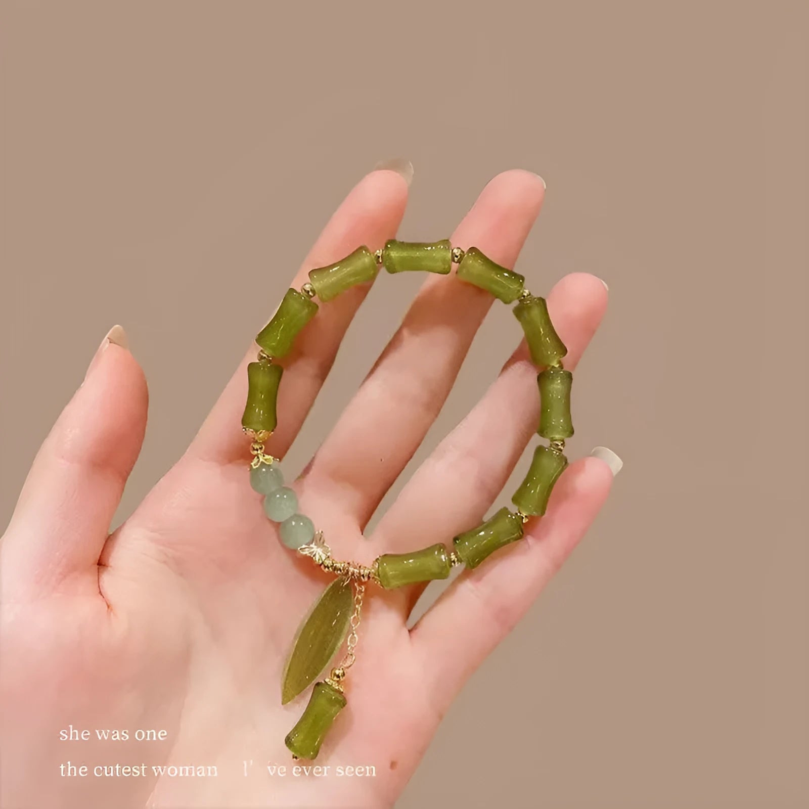 Chinese style glass bracelet with bamboo leaf design on wrist.