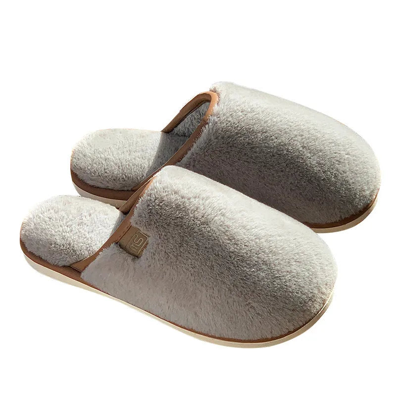 Pair of solid-colour plush PVC slippers with an overshoe design and a textured non-slip sole.