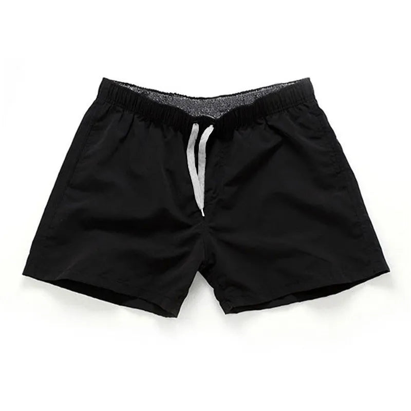 Men's straight-leg polyester beach shorts in black, shown on a model, highlighting the distressed finish and casual fit.