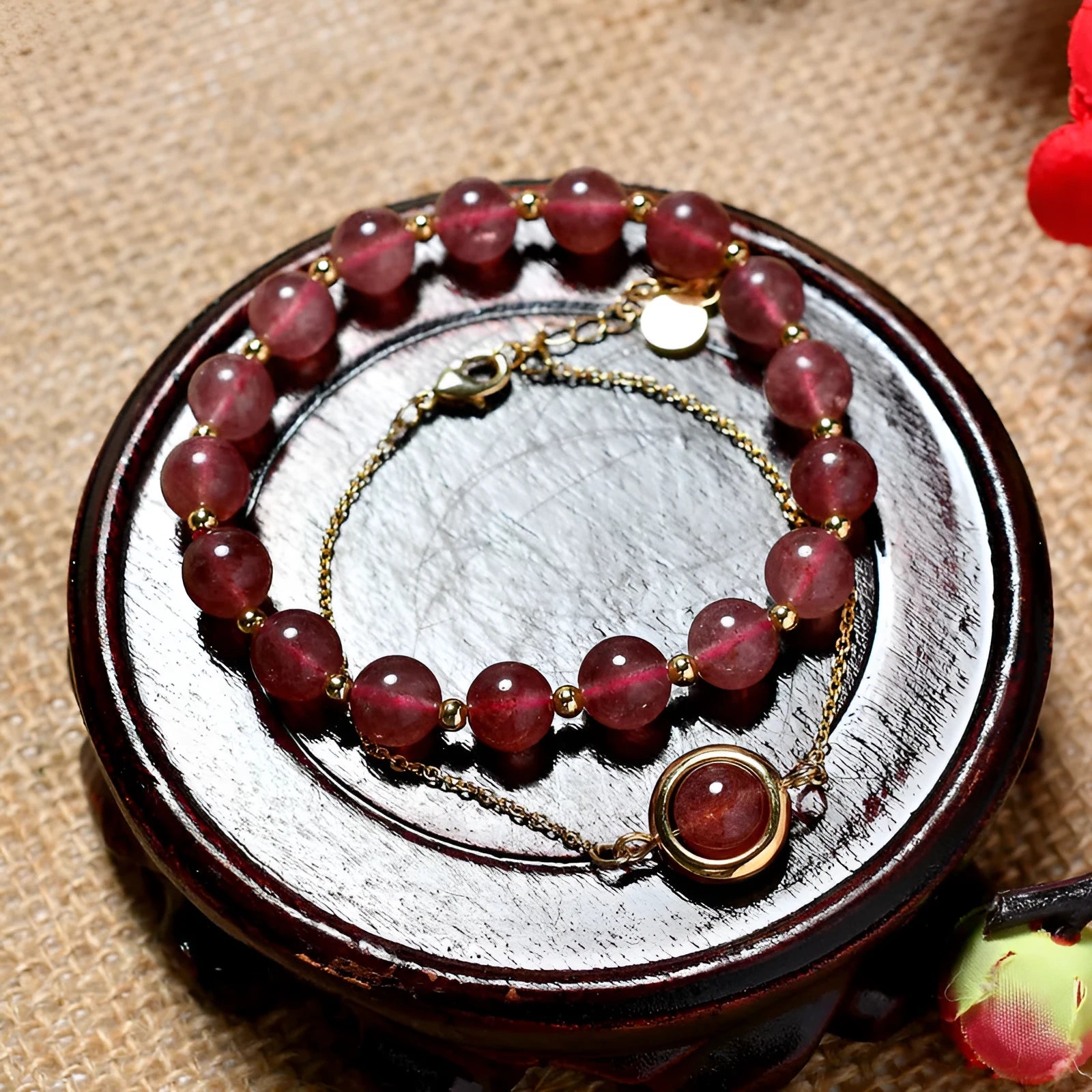 Close-up of a women's double-layer copper bracelet with lucky beads and an electroplated gold finish in a strawberry quartz colour.