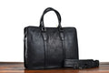 Men's brown leather horizontal business handbag with zipper, shown next to a 14-inch laptop for scale.