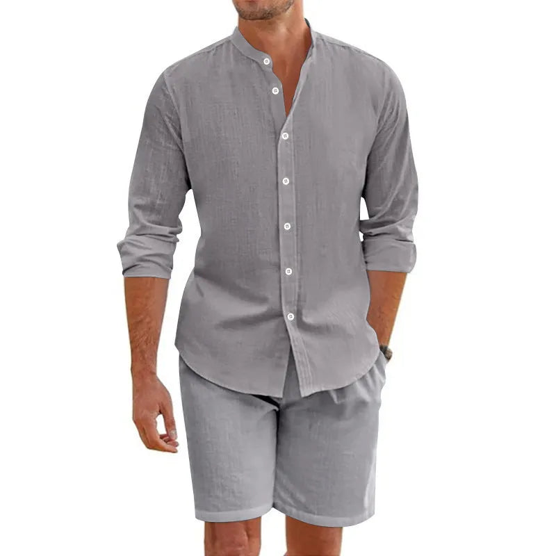Men's dark grey linen-blend short sleeve button-down shirt and matching drawstring shorts on a beach