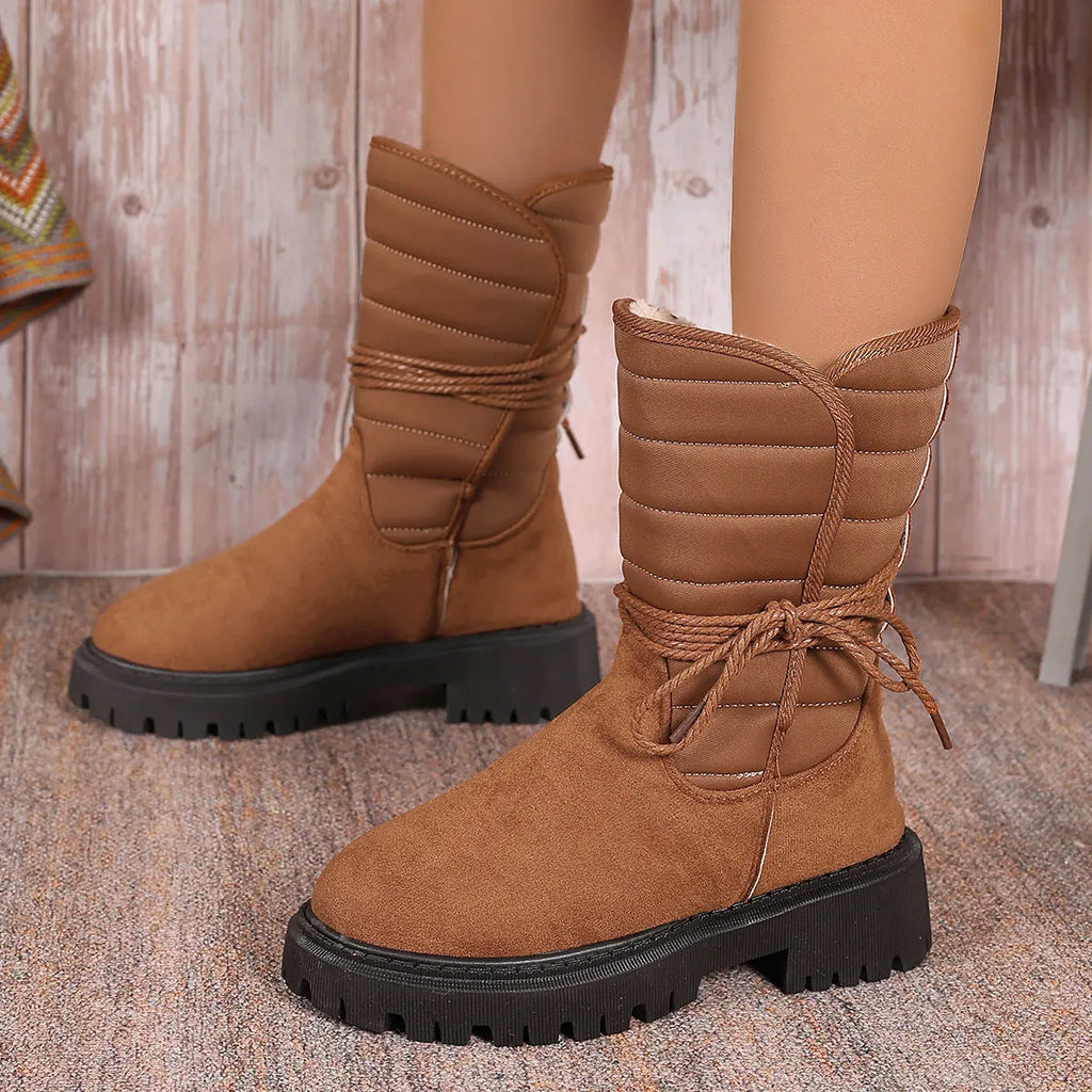 Women's black chunky heel snow boots with lace-up design and suede upper.