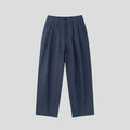 Men's apricot coloured wide-leg cotton linen trousers with a mid waist and zip fly on a neutral background.