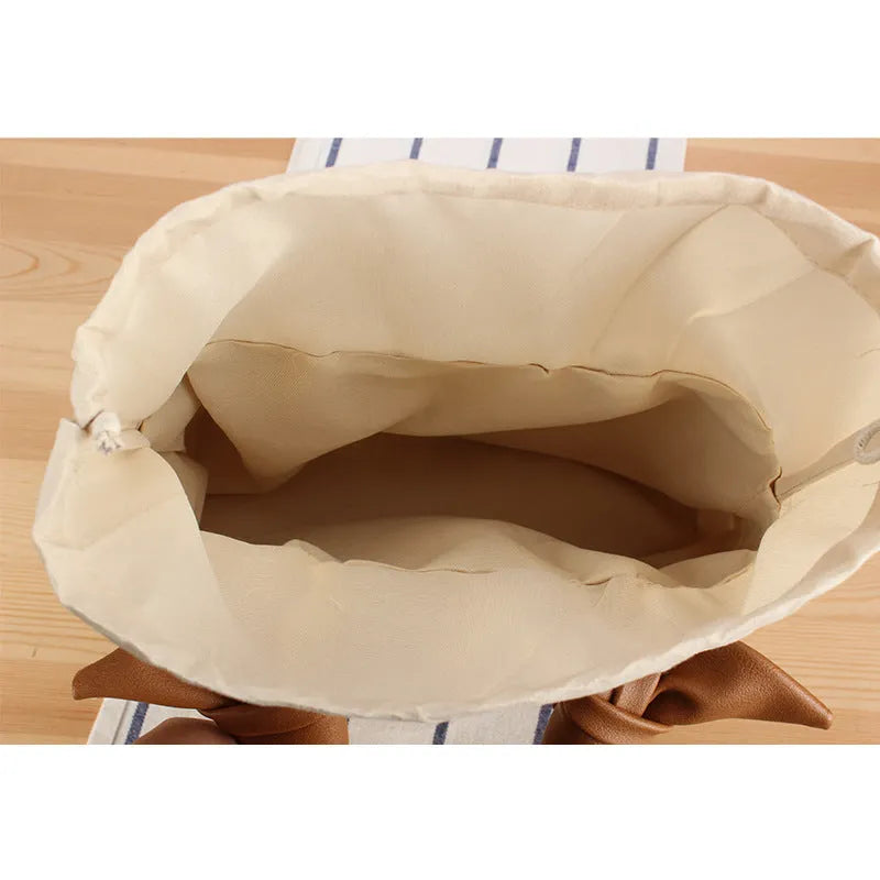 Portable woven straw bag in beige with hard trapezoid shape and double shoulder straps for seaside vacation daily use.
