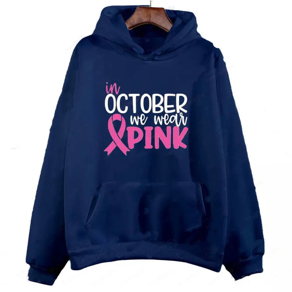 Man wearing a dark blue sweatshirt hoodie with a white retro 'I'm A Survivor' hot stamp print on the front.