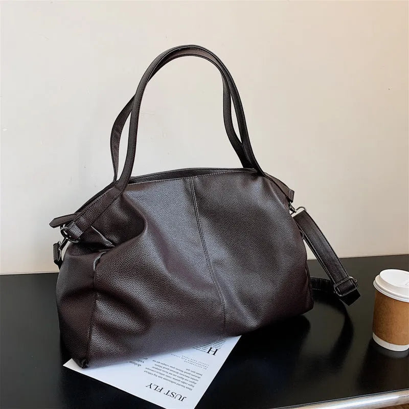 Large horizontal square soft-surface PU leather messenger bag with a long shoulder strap and zip opening.