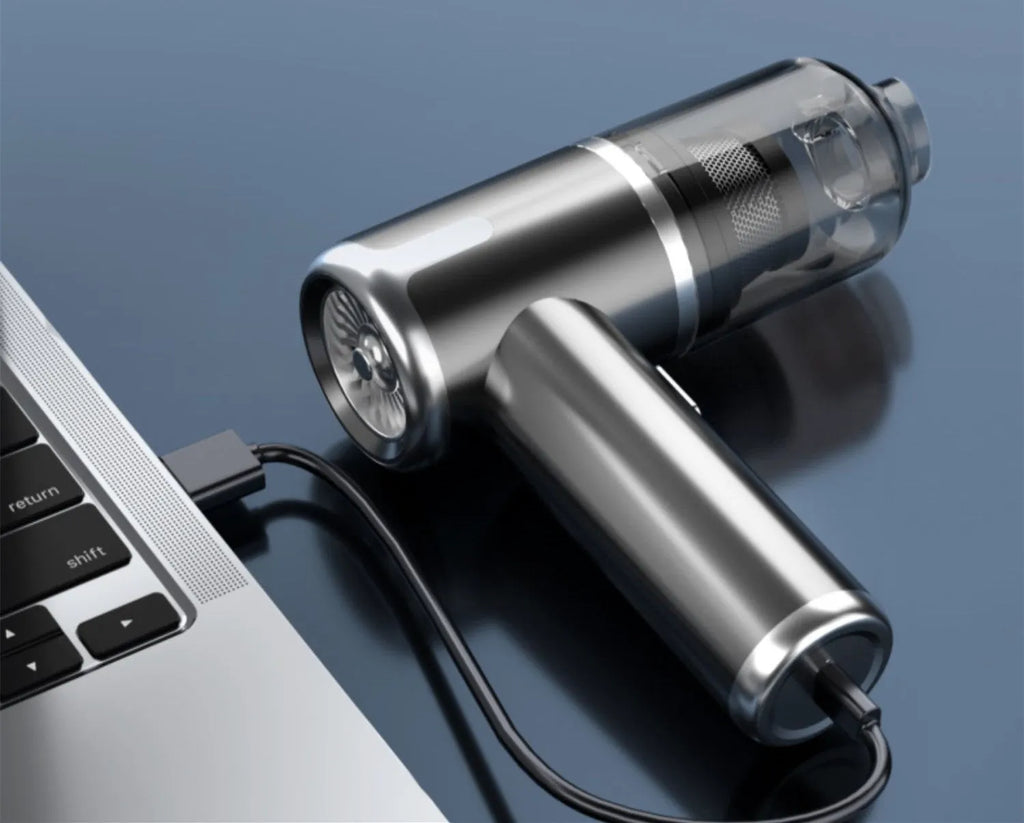 Cordless handheld car vacuum cleaner with attachments on brushed aluminium surface