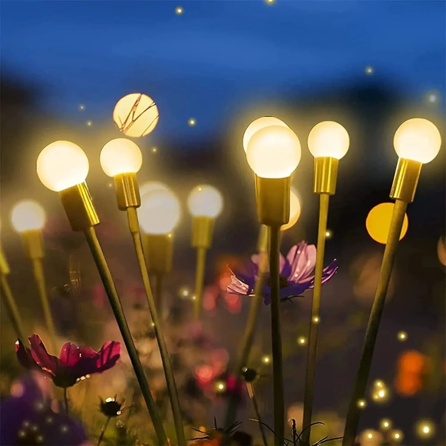 Solar-powered LED firefly garden stake light with stainless steel ground plug illuminated at dusk.