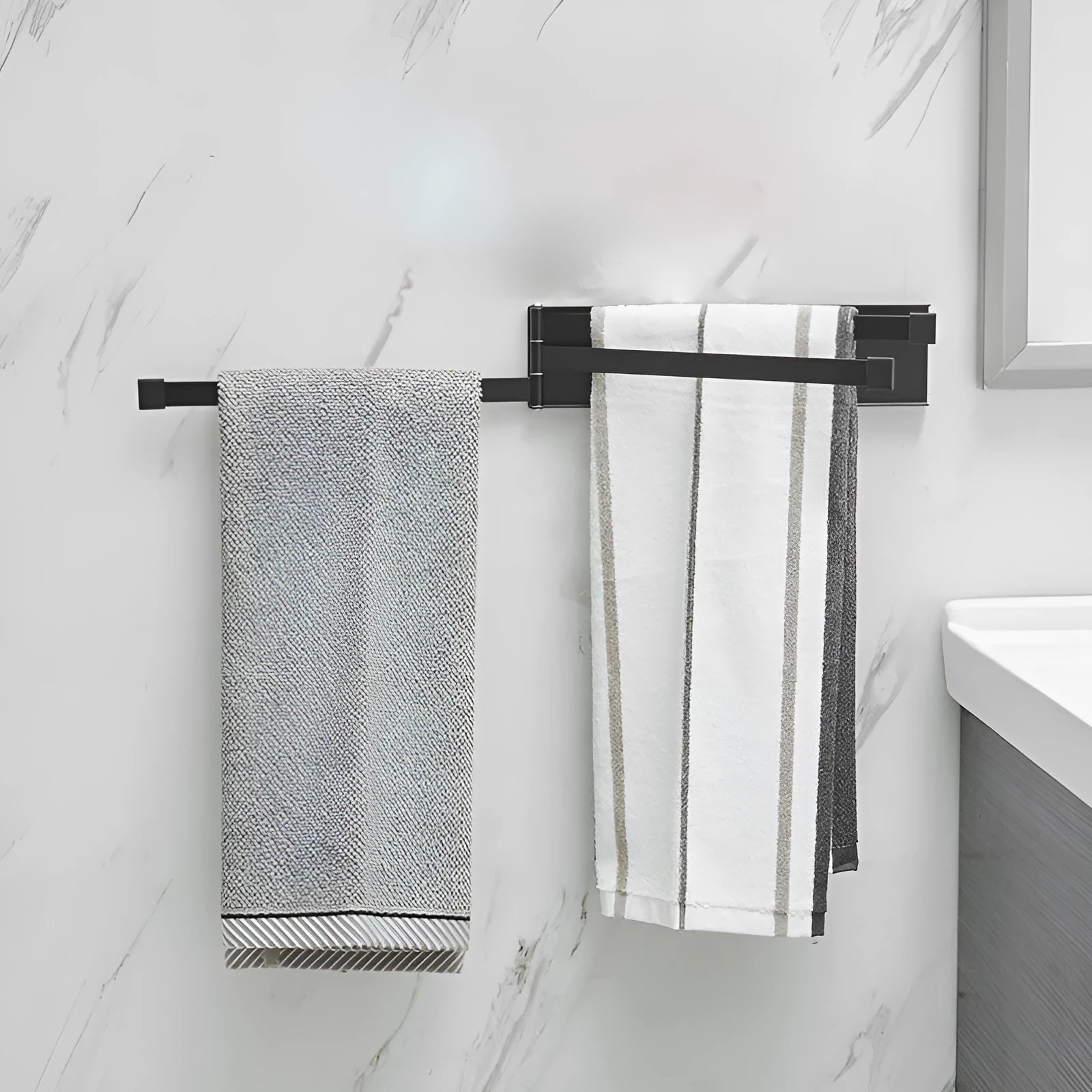 Black folding towel rack mounted on bathroom wall with adhesive installation