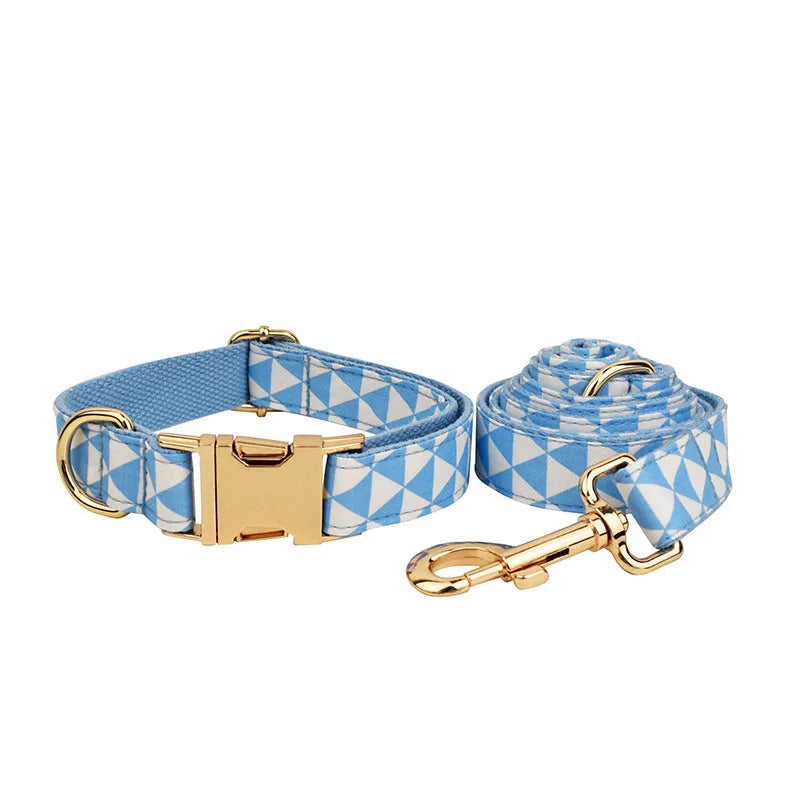Blue cloth dog collar, lead, bow, and vest set laid out flat showing the four matching pieces.