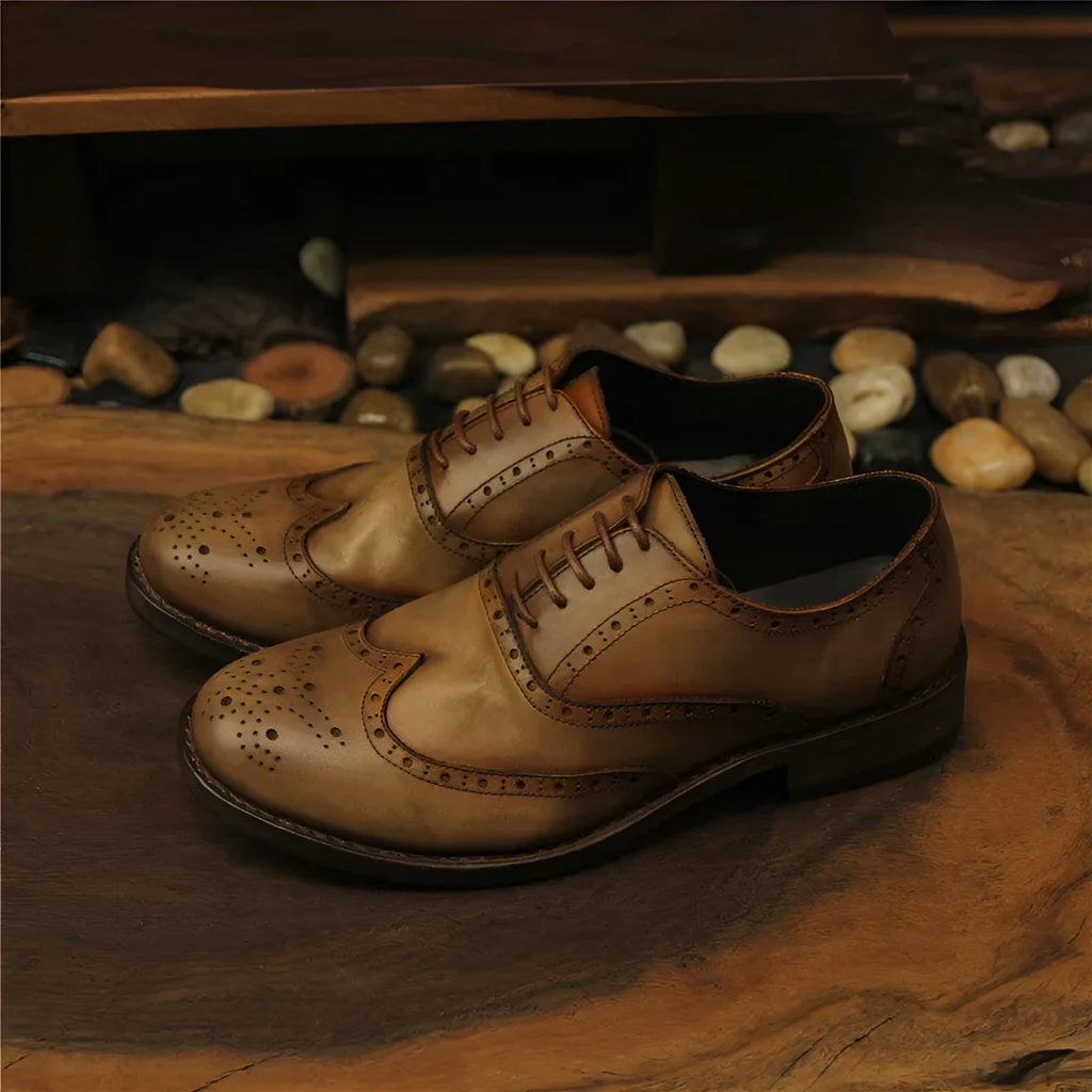 Men's light brown leather lace-up shoes with hand-distressed carving detail on the upper and a round toe.