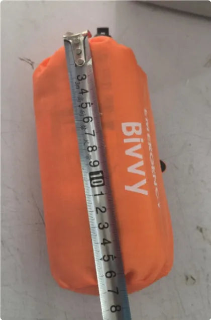 Orange emergency tent with sleeping bag and raincoat for disaster relief camping