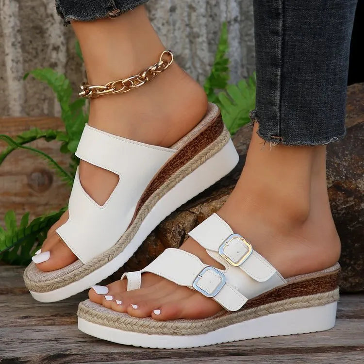 White patent leather women's wedge sandals with finger fit straps and woven detail, peep toe.