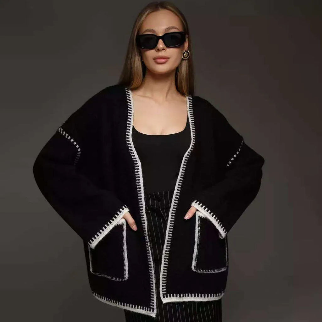 Loose black lace-up knitted cardigan on a hanger