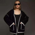 Loose black lace-up knitted cardigan on a hanger
